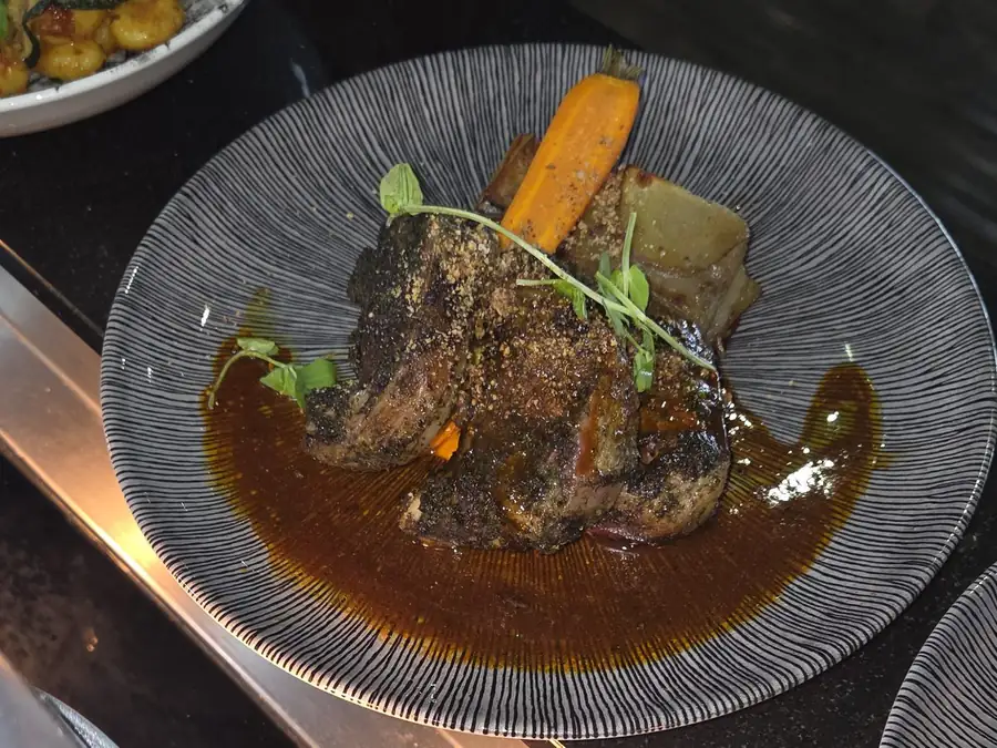 Braised beef with jus, glazed carrot and fondant potato, plated on the pass